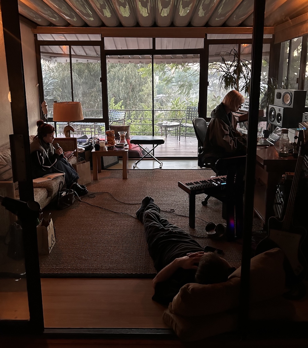 Lily Allen singing vocals from the couch, while producer Kito tracks her in the control room of Blue May’s home studio. Photo: Chloe Angelides 