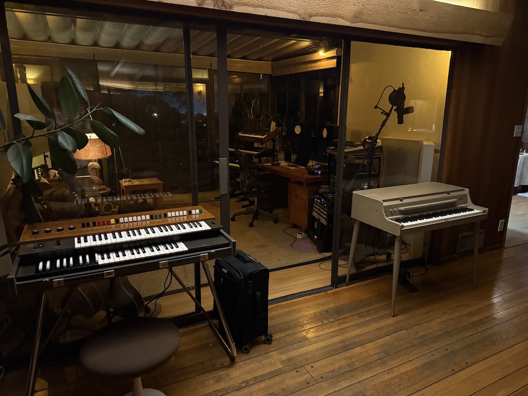 From Blue May’s living room, which is an extension of his studio with some keyboards and a piano, looking into the actual studio control room. Photo: Courtesy of Blue May.