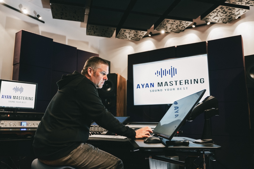 Mastering engineer Adam Ayan seated at his new SPL DMC mastering console, listening out of his Duntech monitors, surrounded by the full-room GiK Acoustics treatment.